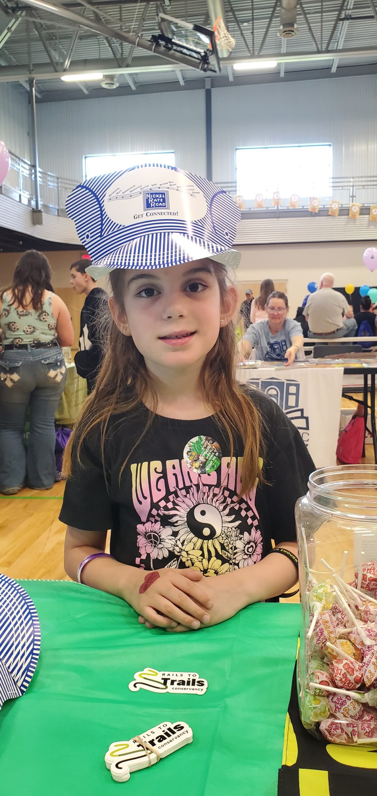 Young girl wearing a Nickel Plate Road engineer hat and smiling at the YMCA Kids Fair