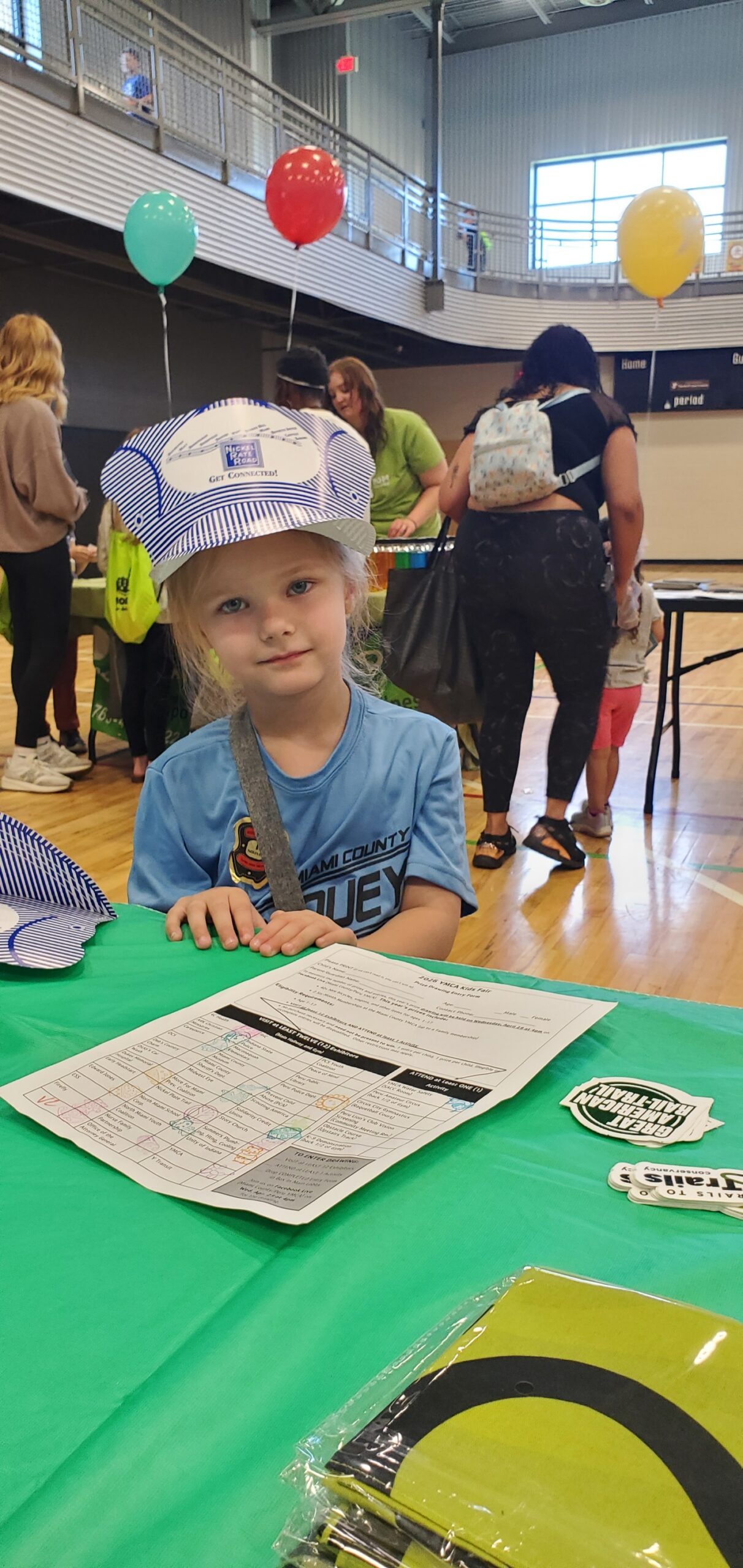 Young girl wearing a Nickel Plate Road engineer hat at the YMCA Kids Fair booth