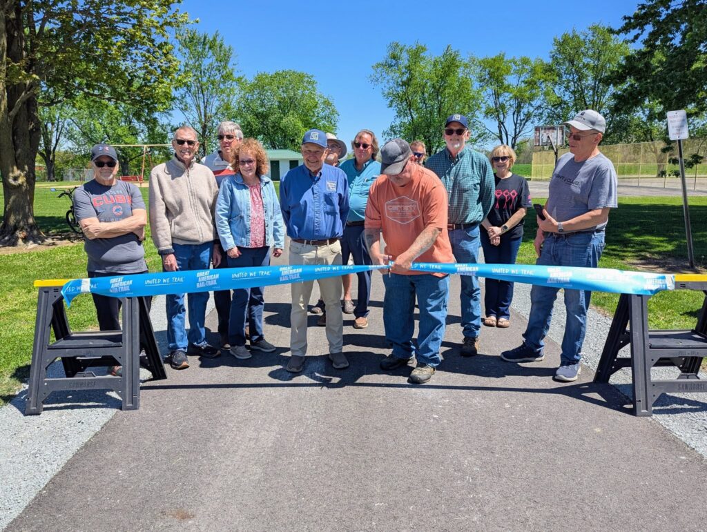 John JR Mercer cuts the ribbon at the MAC Trail grand opening, surrounded by supporters